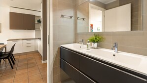A modern bathroom with a large mirror, two sinks, and a potted plant. - Porto Letizia S5, Porlezza, Italy (Porlezza)
