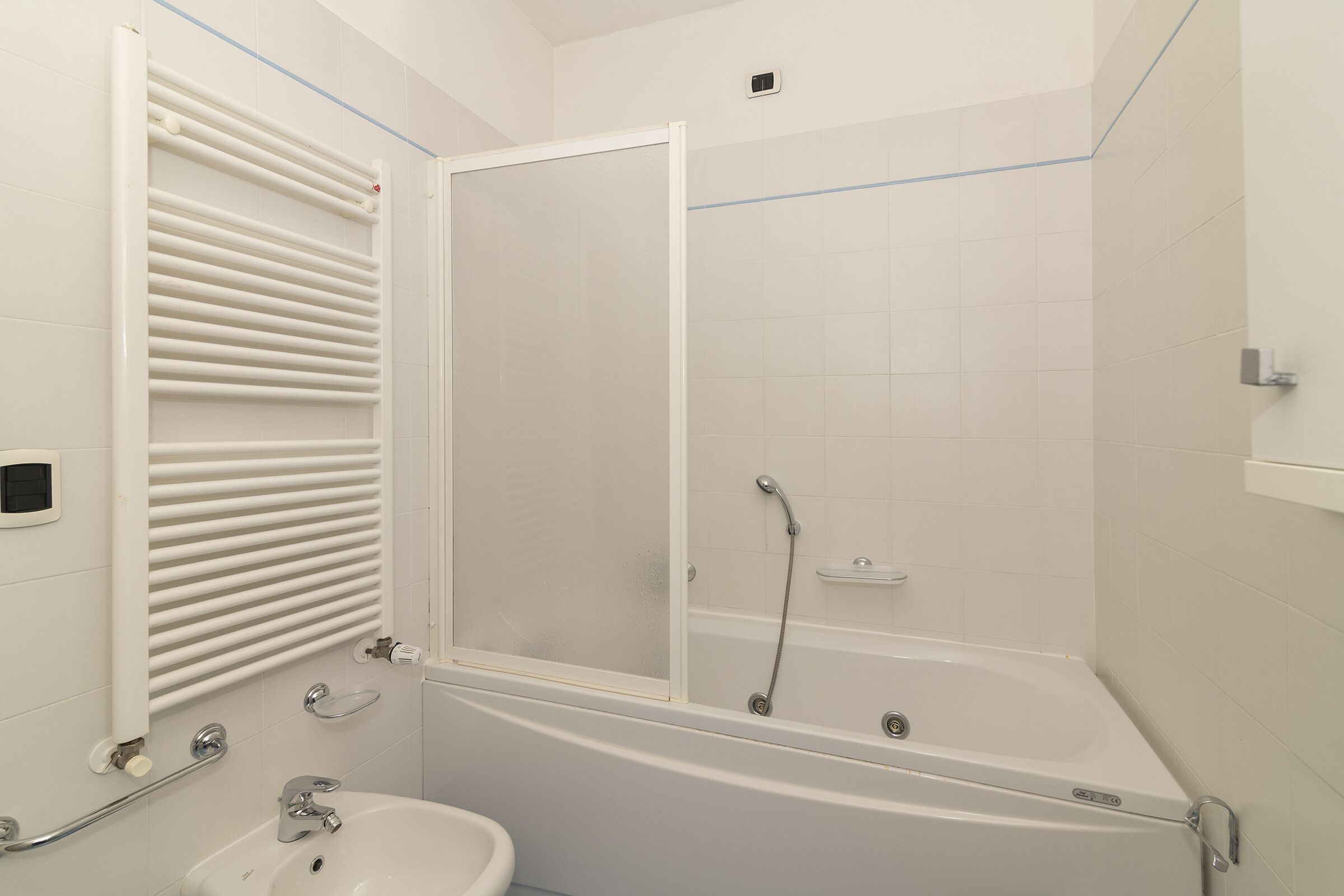 A modern bathroom with a bathtub, a shower enclosure, a toilet, and a sink.