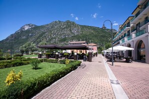 Un chemin pavé mène à des espaces de détente en plein air, avec une vue sur les montagnes en arrière-plan.