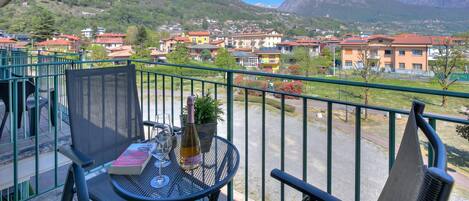 A balcony with a table, a chair, a bottle, and a book.