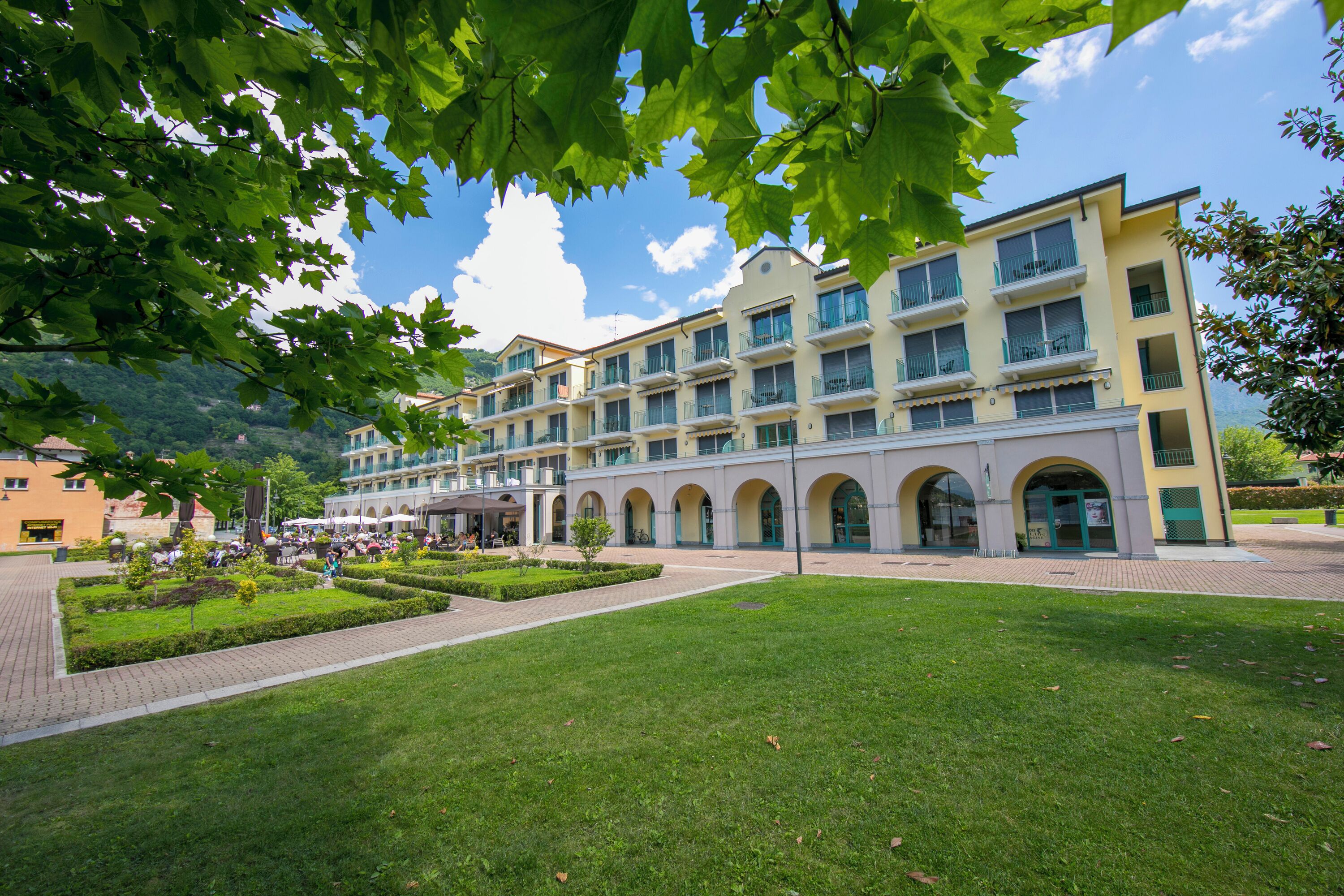 A hotel with a central courtyard, multiple balconies, and a view of the surrounding area.
