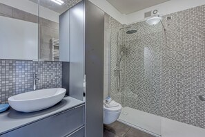 A modern bathroom with a large white sink, a toilet, and a glass-enclosed shower area. - Porto Letizia S10, Porlezza, Italy (Porlezza)