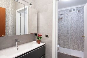 Een bad/douchecombinatie, een haardroger, handdoeken