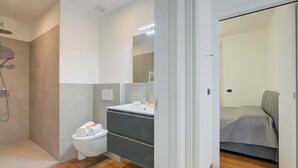 Un bagno moderno con doccia, servizi igienici e lavabo.