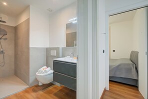 Un baño moderno con ducha, inodoro y tocador.