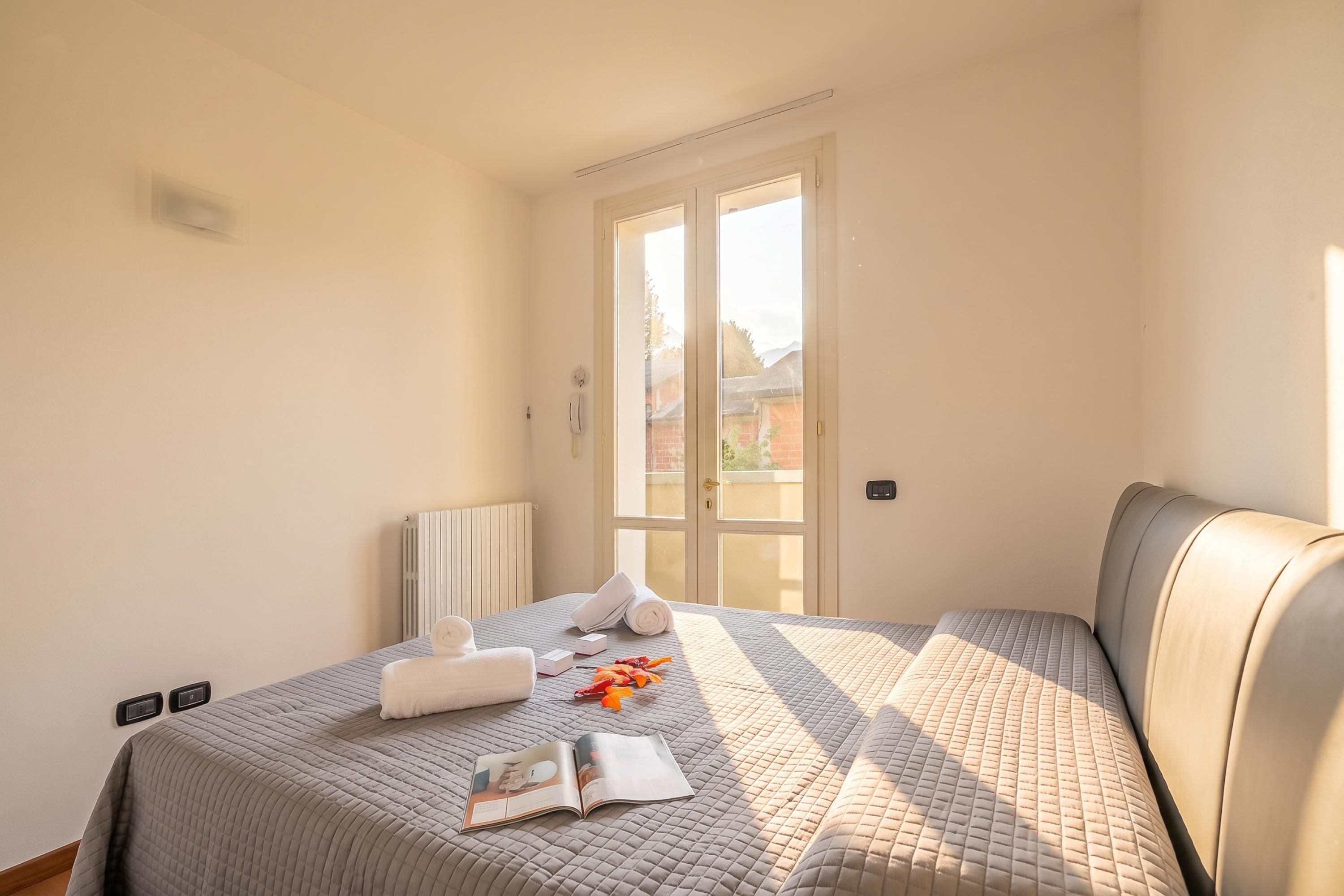 Une chambre d’hôtel avec un lit, un radiateur, une fenêtre et une vue sur l’extérieur.
