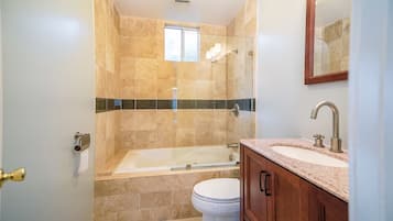 Un baño con bañera, inodoro y lavamanos.
