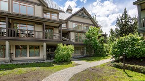 A multi-story building with a covered walkway, large windows, and a landscaped garden. - Luxury 2Br/2Ba Townhouse- Pool, HT, Secure bike storage (Whistler)