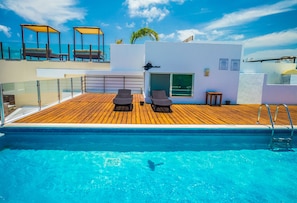 Outdoor pool, a rooftop pool, pool umbrellas, pool loungers