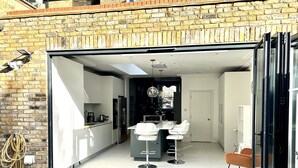 A modern kitchen with white cabinets, a black countertop, and a built-in oven. - Beautiful 4 bedroom Victorian family house on quiet road (London)