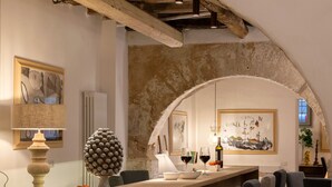 A bar area with a rustic stone arch, wooden chairs, and a long counter. - Dimora Botteghelle (Trapani)
