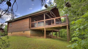 A log cabin with a balcony, surrounded by trees and grass. - Book NOW and receive tickets to Dollywood, Anakeesta and many more (Gatlinburg)