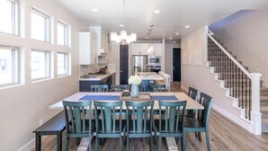 A spacious kitchen with a dining area, large windows, and a staircase. - Sleeps 16 - Private Hot Tub, Fire Pit & Poolside (St. George)
