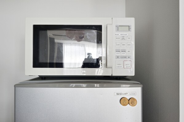 Un horno microondas con pantalla digital y panel de control, integrado en un electrodoméstico metálico.