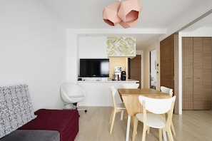 A modern living space with a dining area, a sofa, a TV, and a kitchen area. - Namba 2 bedroom apartment! 1min to Nippombashi (大阪市)