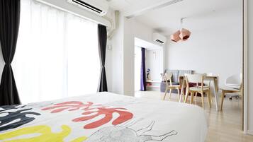 A modern hotel room with a large bed, a desk, and chairs.