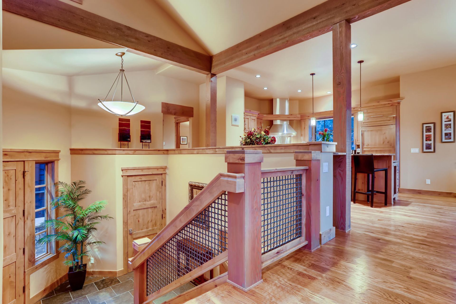 A spacious interior with a wooden staircase, a kitchen area, and a dining space.