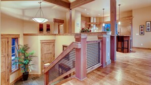 Un intérieur spacieux avec un escalier en bois, un coin cuisine et un espace repas.