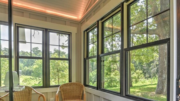 A room with large windows, wicker chairs, and a wooden floor. - Charming Farmhouse Hot Tub Three Acres (Candler)