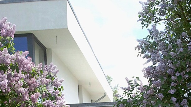 A modern building with large glass doors and a white exterior. - Pension on the Elbe bridge - Apartment New Venice (Berlin)