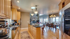 A modern kitchen with wooden cabinets, stainless steel appliances, and a central island. - Sky Valley Home w/ Mtn View, 5 Mi to Rabun Bald! (Sky Valley)