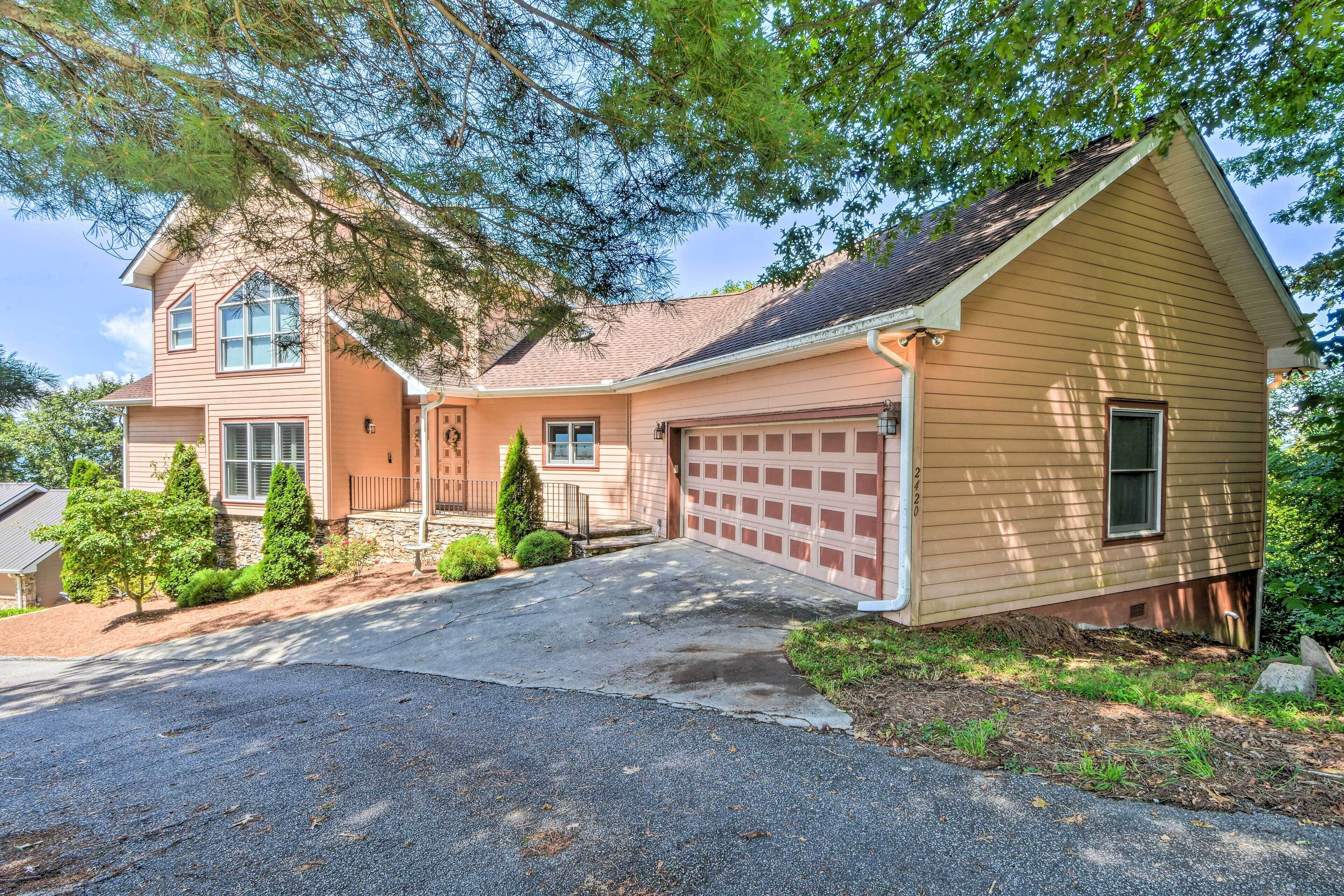 A two-story house with a garage, a driveway, and a well-maintained lawn.