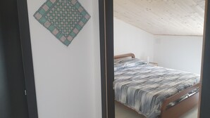 Un dormitorio con cama, techo de madera y una obra de arte colgada en la pared.