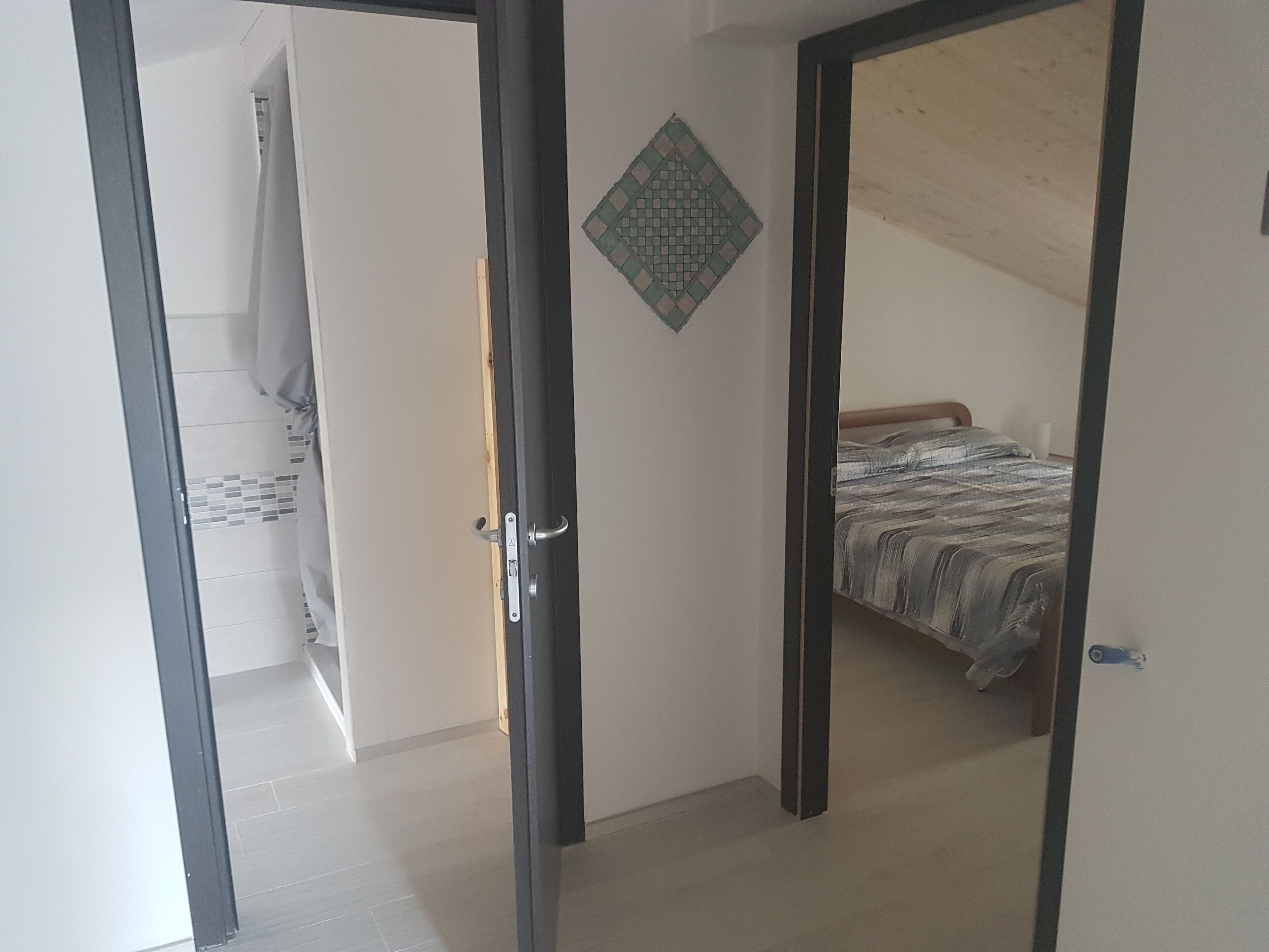 Ein Zimmer mit einem Bett, einem Kleiderschrank und einer Tür zu einem anderen Raum.