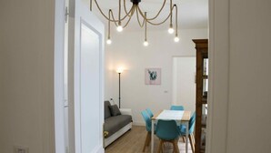 A dining area with a table and chairs, a sofa, and a chandelier. - Fabiana house, apartment in the historic center for short or long periods (Napoli)