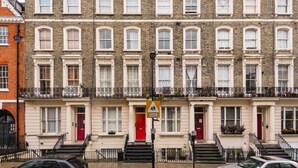 A row of townhouses with uniform architecture, a school sign, and a parking sign. - Comfy Bayswater Apartment (London)