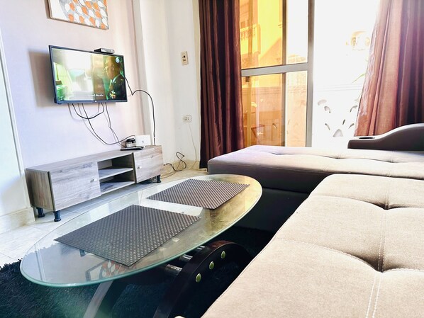 Relax in this stylish living room with a flat-screen TV, entertainment unit, and comfortable sofa.
