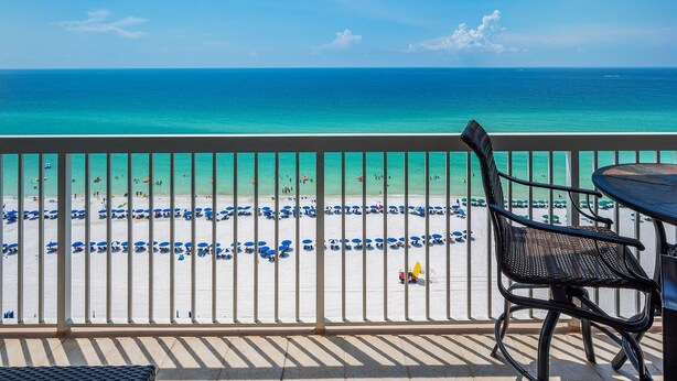 Ein Balkon mit Blick auf Strand und Meer.