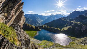 A mountainous landscape with a lake and a rocky cliff. - Studio in the city center (Barcelonnette)