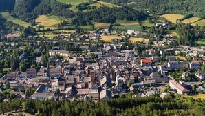 A town with a mountainous backdrop, featuring a mix of residential and commercial buildings, surrounded by greenery and open fields. - Studio in the city center (Barcelonnette)