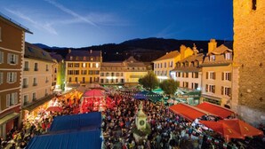 A bustling square with historic buildings and a prominent tower. - Studio in the city center (Barcelonnette)