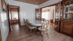 A dining area with a wooden table and chairs, a cabinet with glass doors, and a wooden ceiling. - Large close to Downtown appartment (Ushuaia)