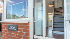 Eine Ziegel-Fassadenwand mit einem Schild, auf dem 'High View 11 Russell Close' steht.