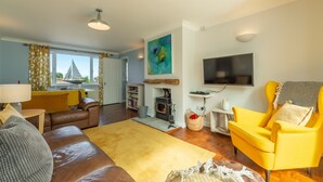 Ein Wohnzimmer mit einer Couch, einem gelben Sessel und einem Kamin.