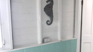 A reception area with a seahorse decoration, a sign indicating vacation availability, and a teal-colored wall. - COZY BEACH HOUSE 2 BEDROOM (Treasure island)