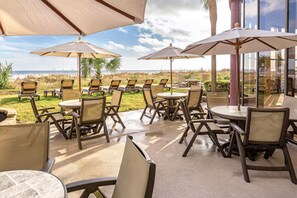 An outdoor patio with tables and chairs, umbrellas, and a view of the beach. - Two Bedroom Ocean View Luxury, Myrtle Beach 1751742 (North Myrtle Beach)