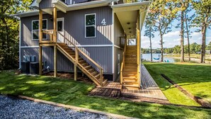 A two-story house with a wooden staircase leading to a covered porch.