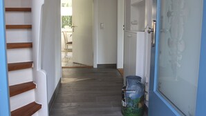 A hallway with wooden steps leading to a door with frosted glass. - Holiday house in the center of Jever - In the house time-out, outside Frisian-tart (Jever)