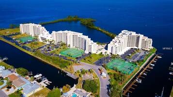 Un hôtel de grande hauteur doté de nombreux balcons offrant une vue sur une marina et l’océan.