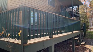 A wooden cabin with a green deck and a small staircase leading to an upper level. - Lake Superior Waterfront home (Brimley)