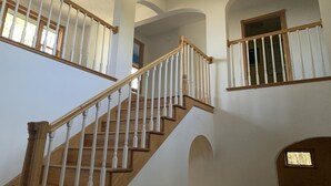 A multi-level interior with a wooden staircase, white railings, and arched ceilings. - Lake Superior Waterfront home (Brimley)