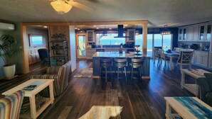 A spacious kitchen with a large island, wooden flooring, and a view of the ocean. - Ocean Front Home- spacious, beautiful yard, hot tub & ocean view all around!! (Brookings)