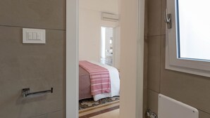A bedroom with a bed, a bedside table, a window, and a door. - Puglia holiday apartment in Monopoli (Monopoli)