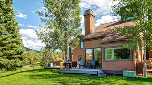 Una casa moderna con terraza, ventanas amplias y una chimenea.