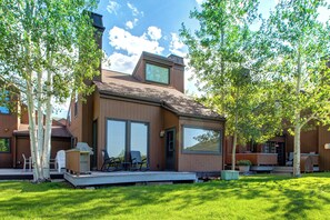 A modern house with a deck, large windows, and a yard with trees. - Stunning Views, Golf, Outdoor Recreation + Community Amenities! Park City Three Kings 61 (Park City)