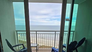 A balcony with a view of the beach, two chairs, and a table. - Luxury oceanfront condo w/ Breathtaking views. Lazy River, pools, hot tubs. (North Myrtle Beach)